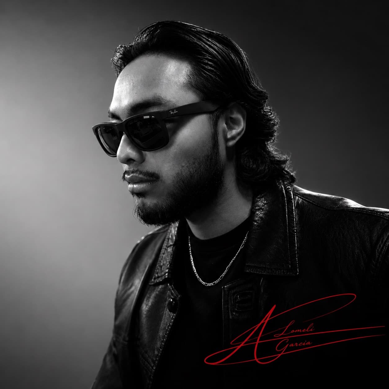 Studio portrait of Alexander Lomeli in sunglasses and a leather jacket